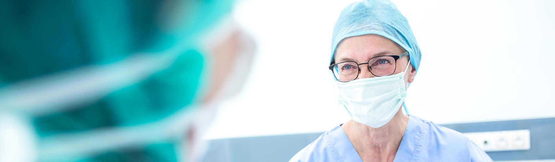 A female doctor smiling through a mask