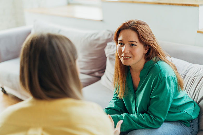 Two women talking on couch