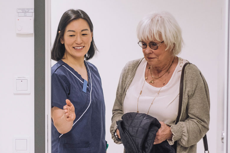 Nurse guiding patient into room